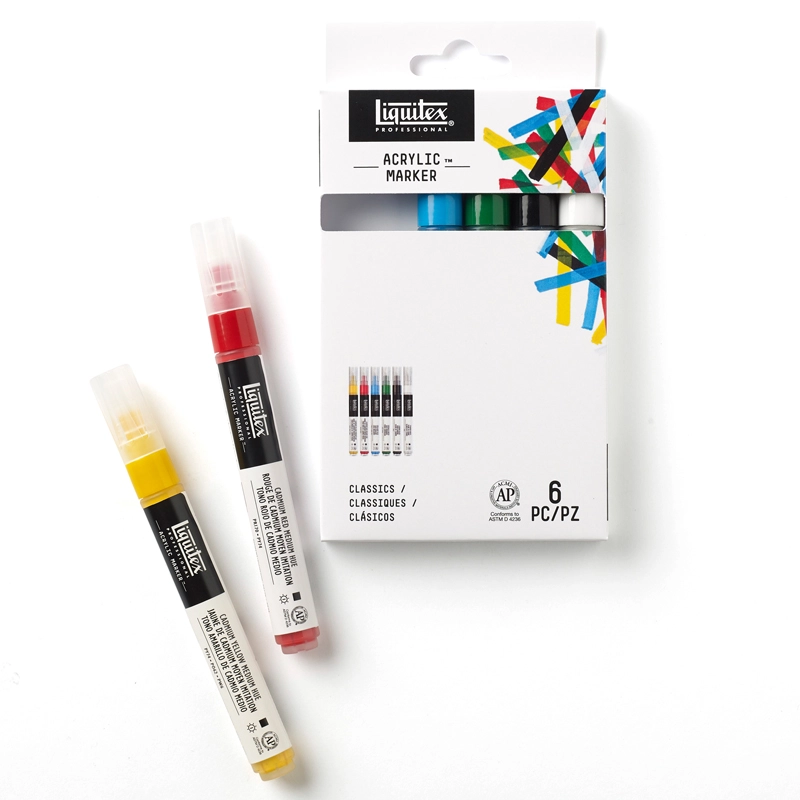 Komplet mazaków akrylowych Liquitex Acrylic Marker Classics na białym tle, z leżącymi obok dwoma markerami z zestawu.